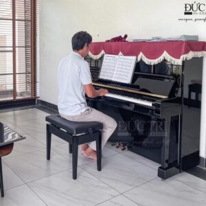 Khách hàng đang chơi và trải nghiệm đàn piano Yamaha YUS5 tại showroom của Piano Đức Trí