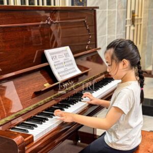 Khách hàng nhí đang chơi đàn Yamaha U300MHC