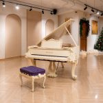 Đàn piano Bösendorfer Baroque trắng trong phòng trưng bày có cây thông noel