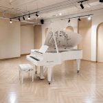 Góc nhìn nghiêng đàn piano bosendorfer cocteau trắng trong phòng vòm sáng