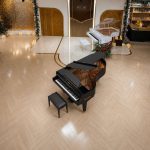 Góc nhìn trên cao bao quát đàn piano Bösendorfer 200 đen trên sân khấu gỗ, nắp mở