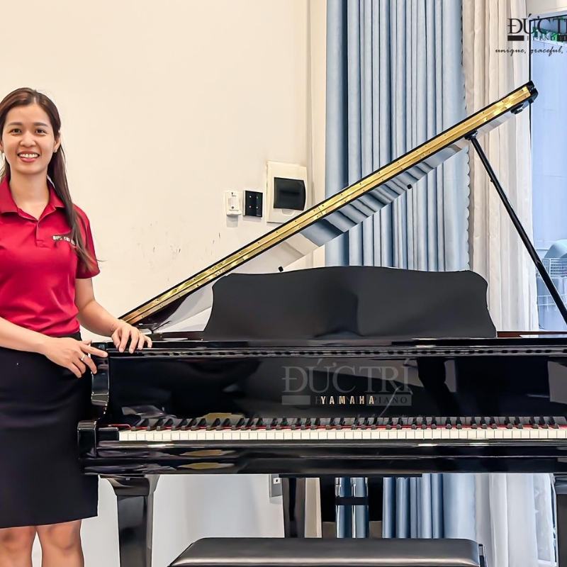 Nhân viên của Piano Đức Trí chụp hình cùng chiếc đàn Yamaha CFX
