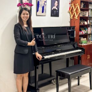 Khách hàng chụp hình cùng với chiếc đàn piano Yamaha YUS5