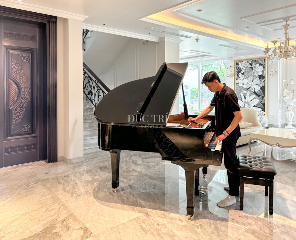 Nhân viên kỹ thuật của Piano Đức Trí đang điều chỉnh dây đàn Yamaha C1 cho khách hàng