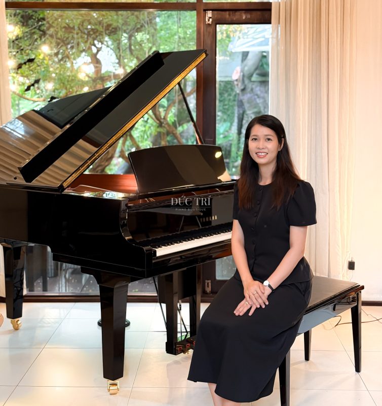 Nhân viên Piano Boutique Đức Trí ngồi bên đàn Yamaha DC2X Disklavier