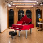 Bösendorfer Porsche - Đàn piano đỏ trong phòng trưng bày library với kệ sách gỗ