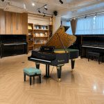 Cận cảnh đàn piano Bösendorfer Secession với nắp hoa văn vàng và ghế xanh